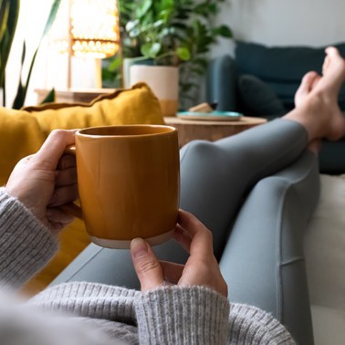 Woman relaxing on a couch with a mug in her hand