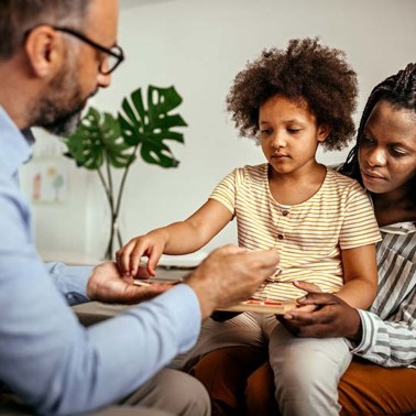Mom and daughter sitting with a doctor