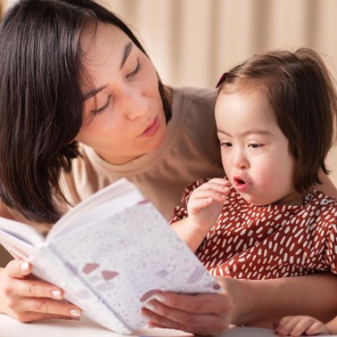 Mom holding and and reading to her daughter