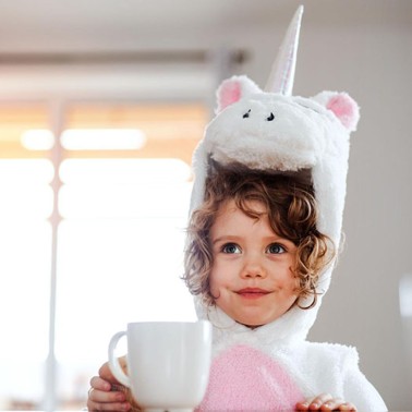 Girl in a unicorn costume holding a mug