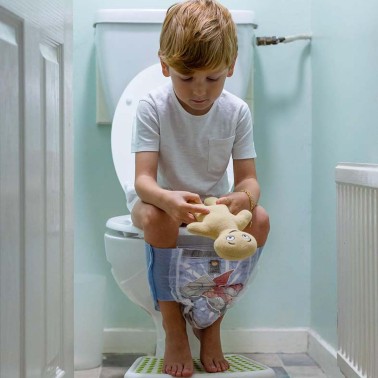 Boy on the toilet holding his soft toy