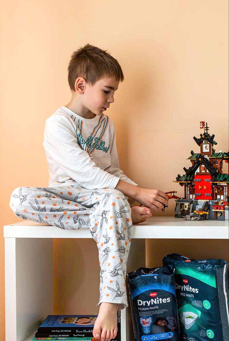 Boy in pyjamas playing with toys