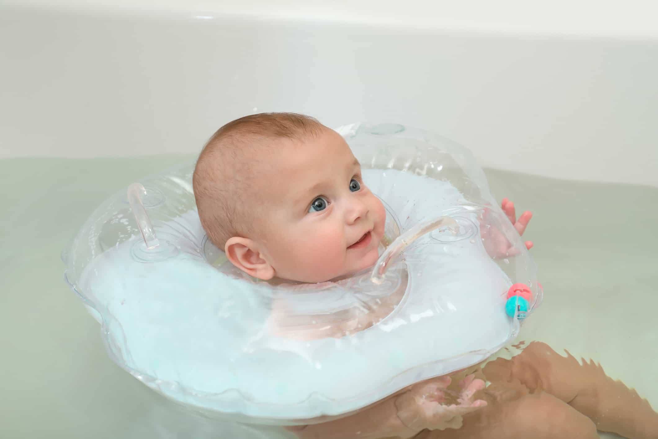 Baby with neck floating device in bath