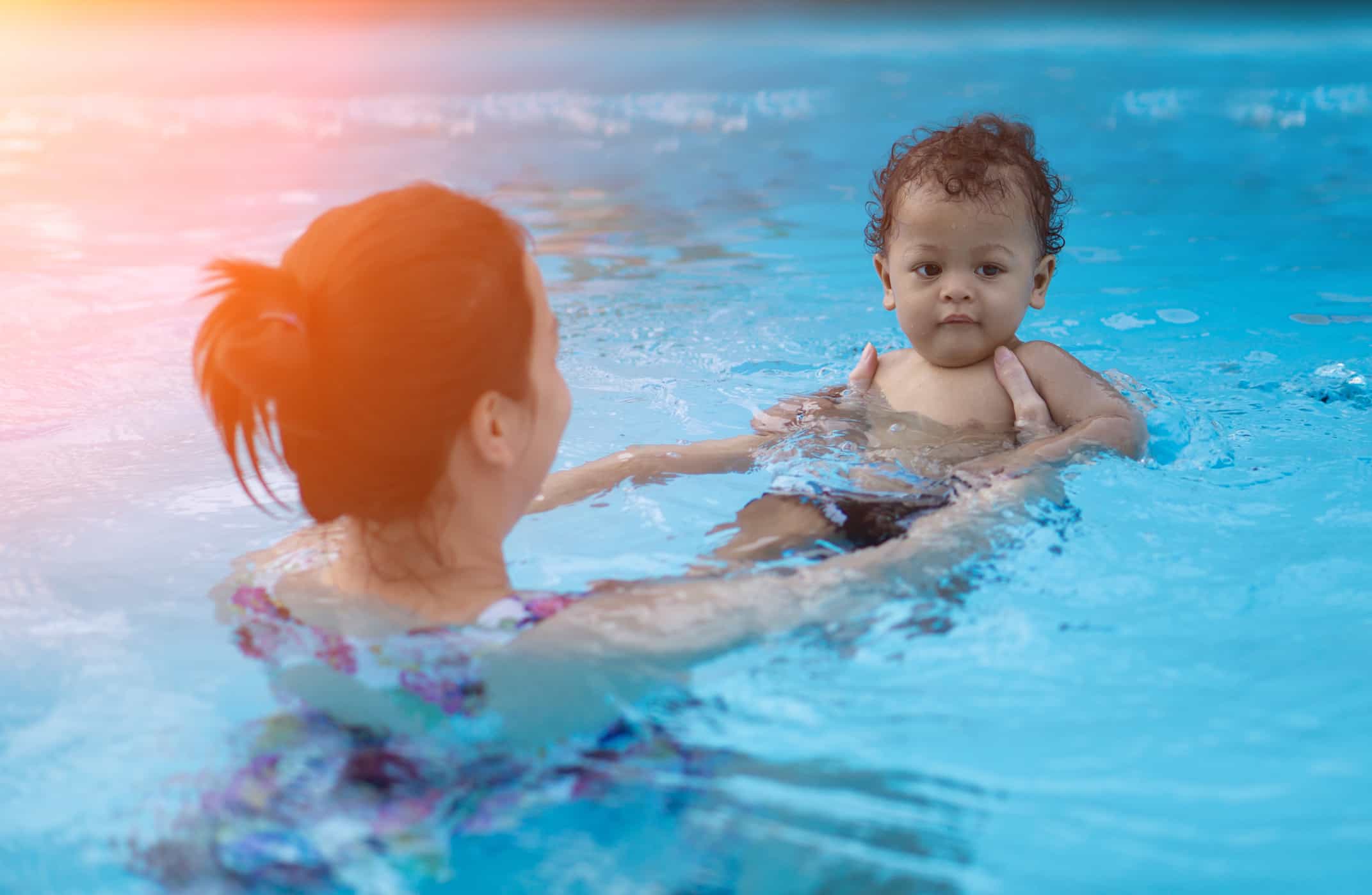 Woman swimming with baby in a pool